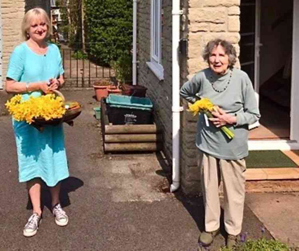 Maggie Charlesworth keeps a safe distance as she brings gifts of daffodils and cake