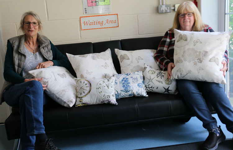 Carolle Skeates, right, shows her hand-made cushions to Heads Up staffer Sally Dempsey