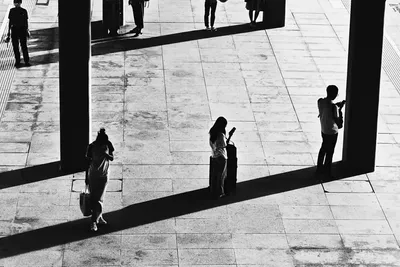 Abstract Numr artwork: three figures spread across an empty platform.