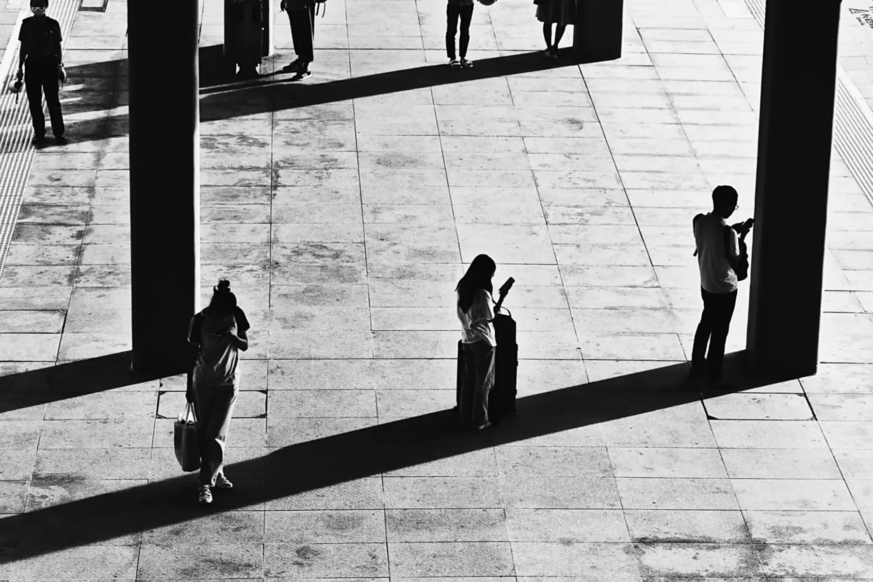 Abstract Numr artwork: three figures spread across an empty platform.