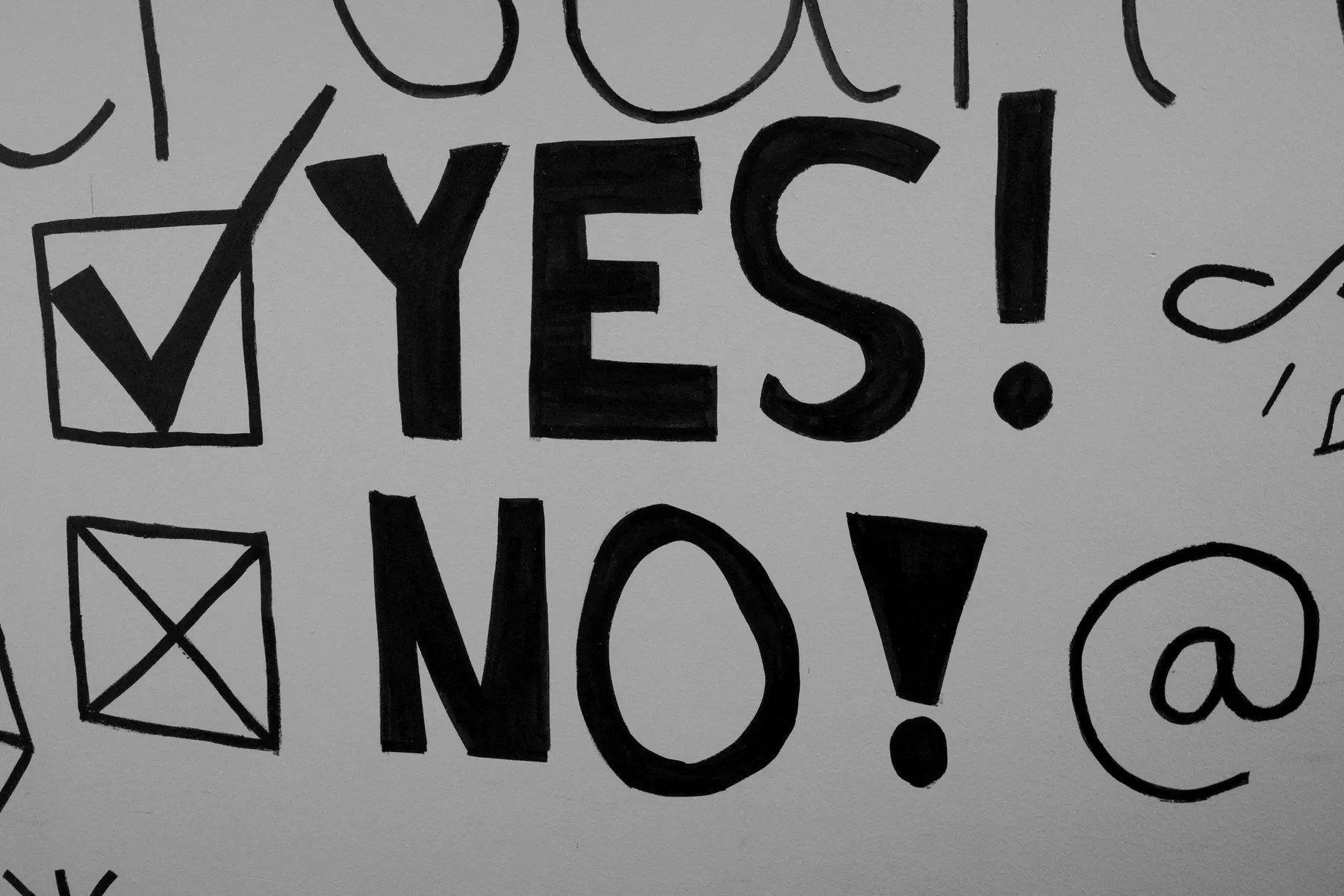Hand-drawn in black marker on a whiteboard: a ticked box beside the word YES, and a crossed box beside the word NO.