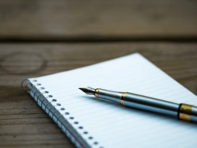 A person writing down their fitness goals in a notebook.