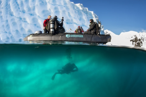 Polar Diving, zodiac in front of iceberg, diver diving under zodiac, Antarctica