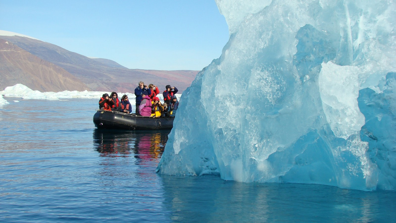 Zodiac cruising among massive icebergs