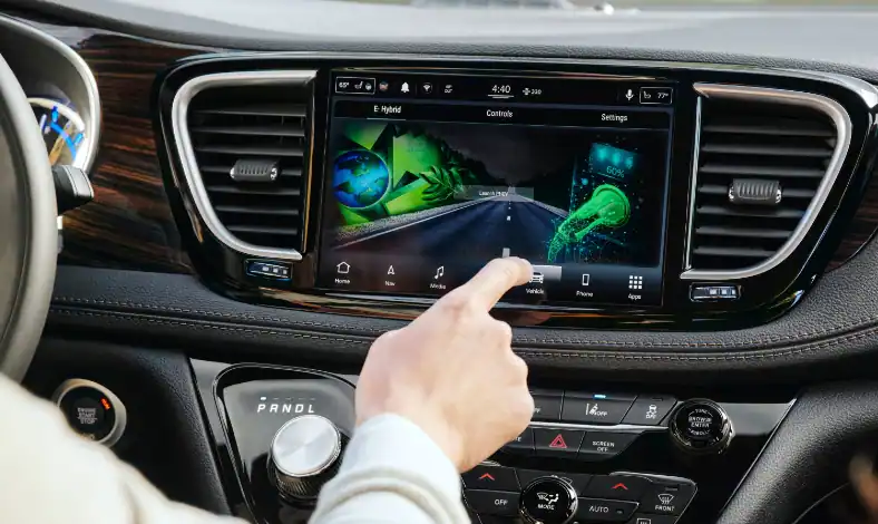 A person using the Chrysler Pacifica Hybrid 10.1-inch color touchscreen and Uconnect® 5