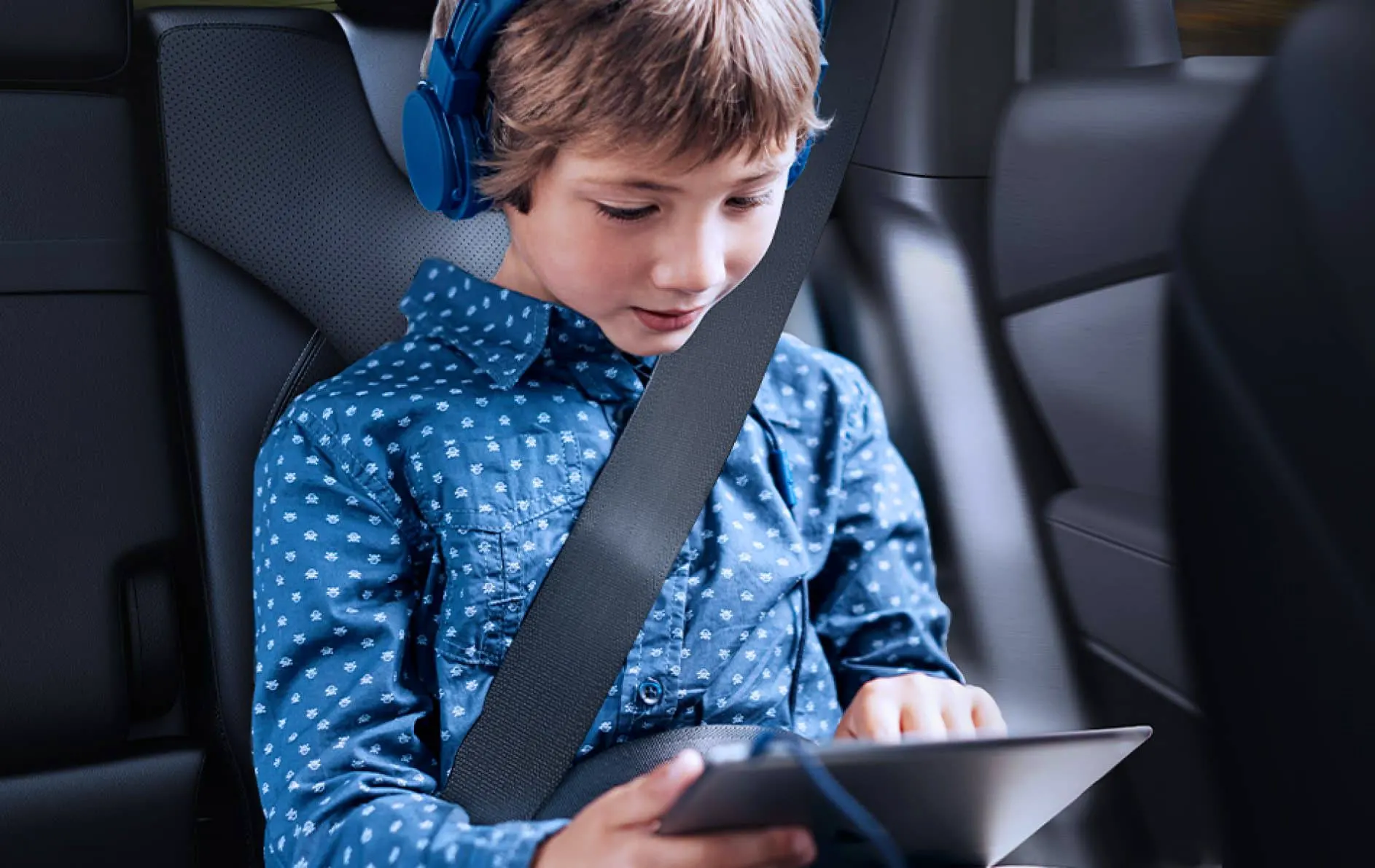 Child looking at his tablet with headphones while using the 4g hotspot