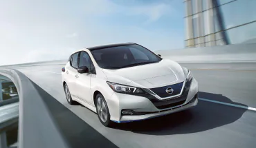 White Nissan LEAF driving down the road