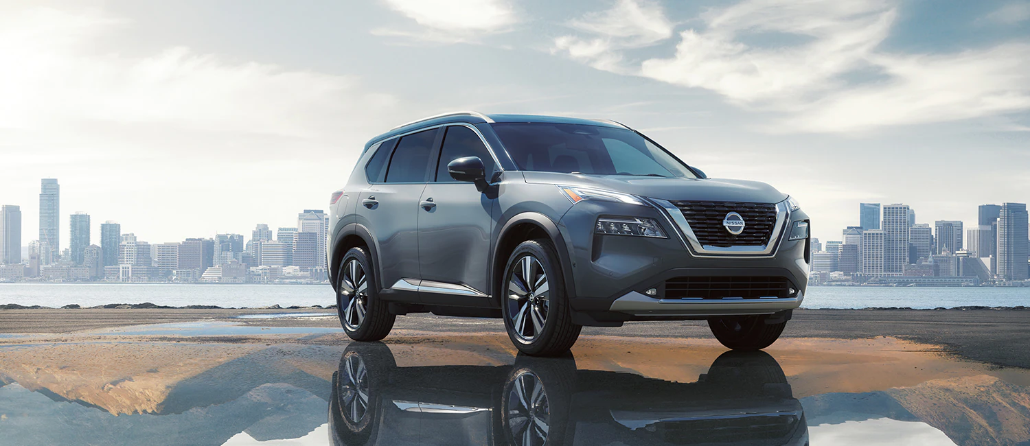2022 Nissan Rogue shown in gray with city on the background.