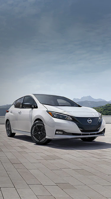 2024 Nissan LEAF in white parked with mountains in the background