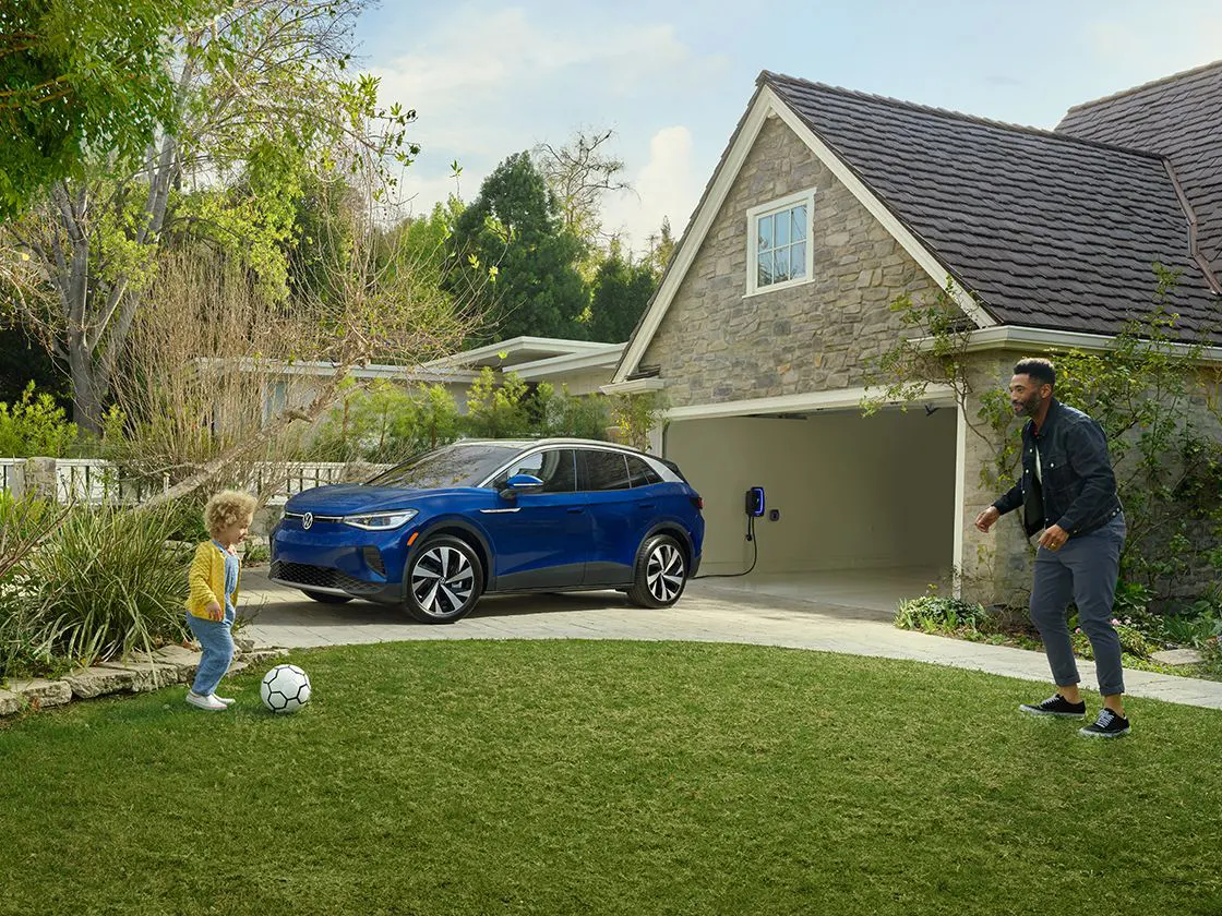 Blue ID.4 parked in driveway with dad and daughter playing soccer