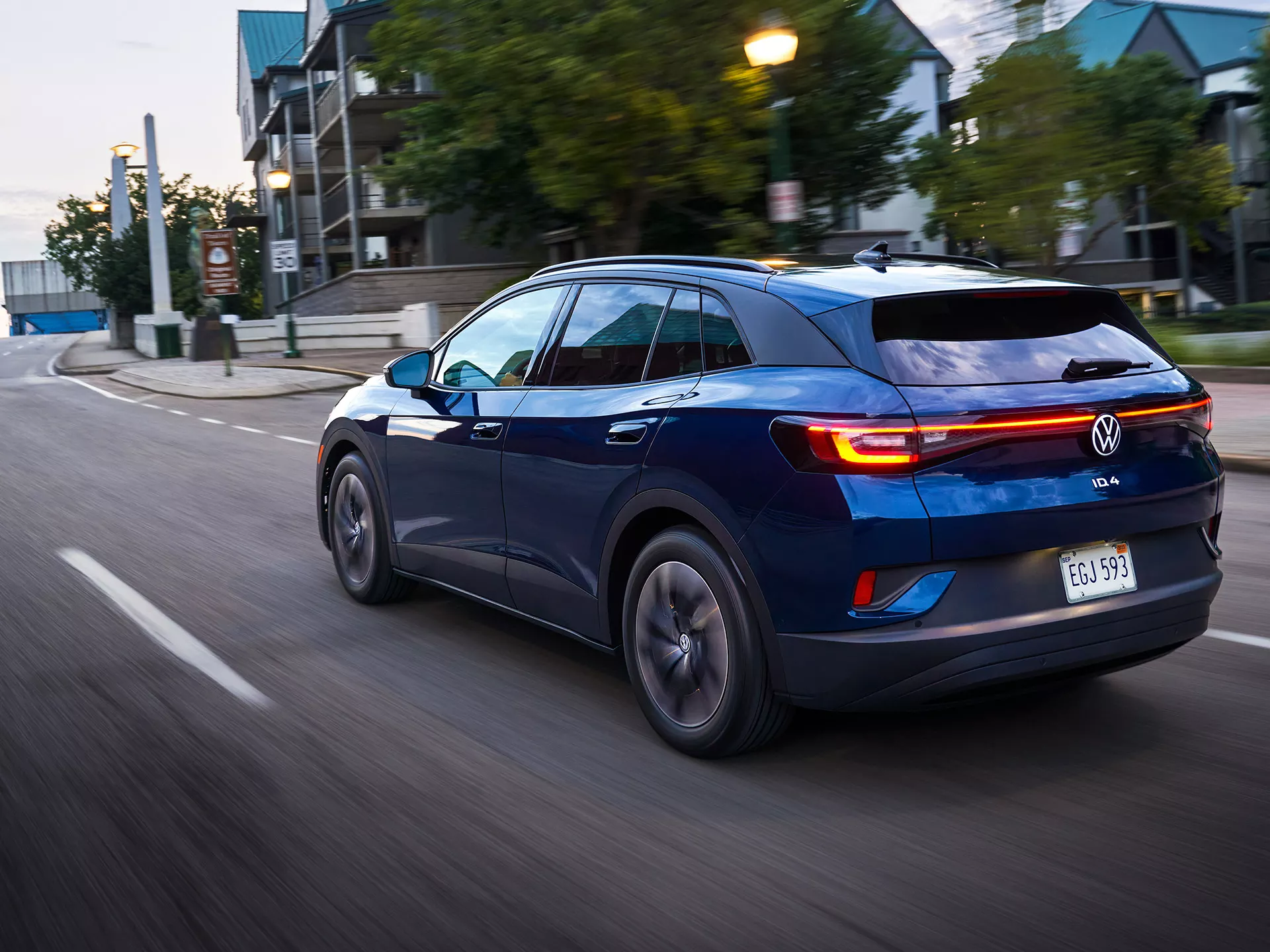 An ID.4 in Tourmaline Blue Metallic drives along a city street.