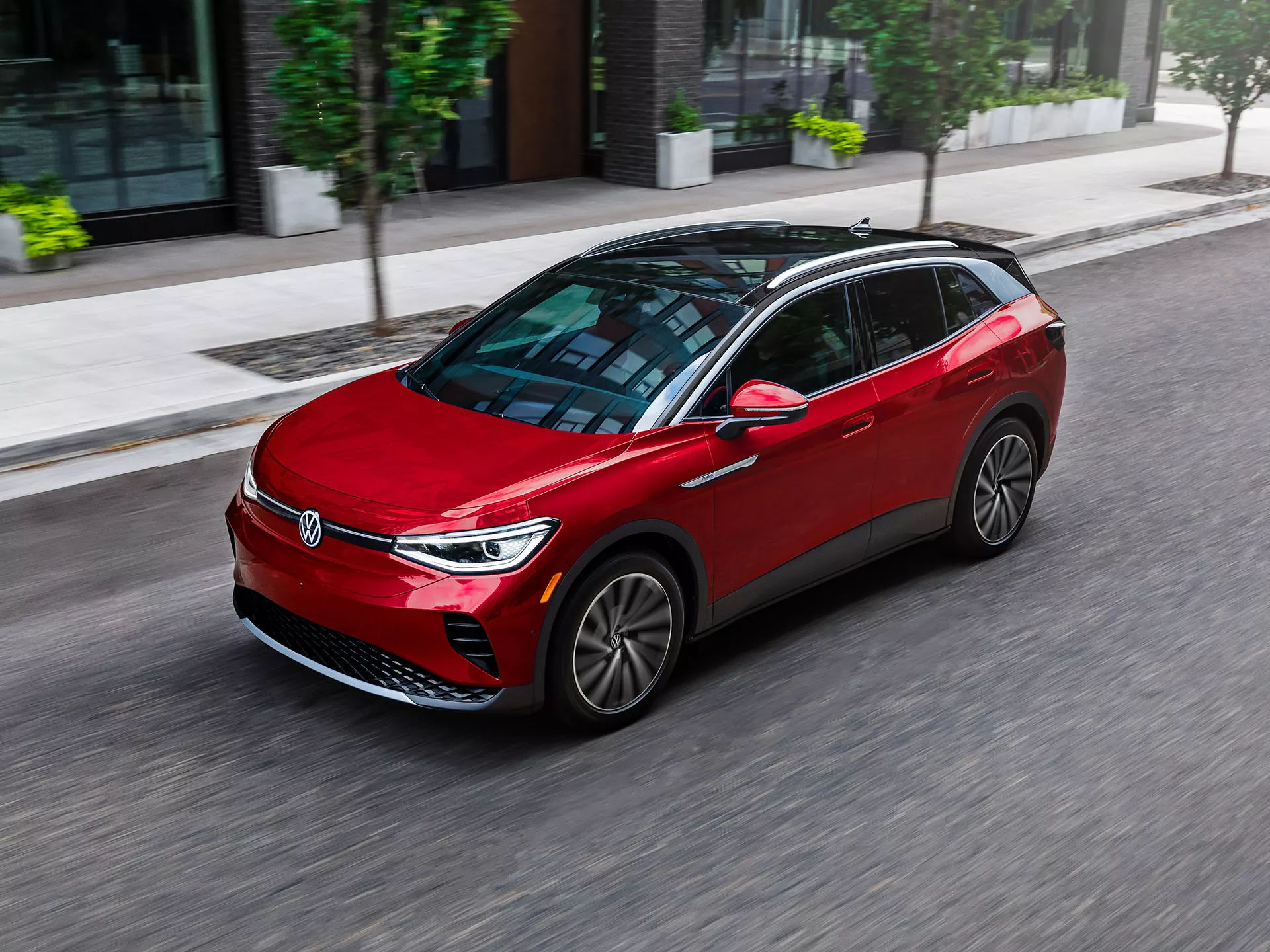 2023 VW ID.4 Electric Performance Range Front, medium-angled shot of an ID.4 SUV shown in Aurora Red Metallic, driving on a city street.
