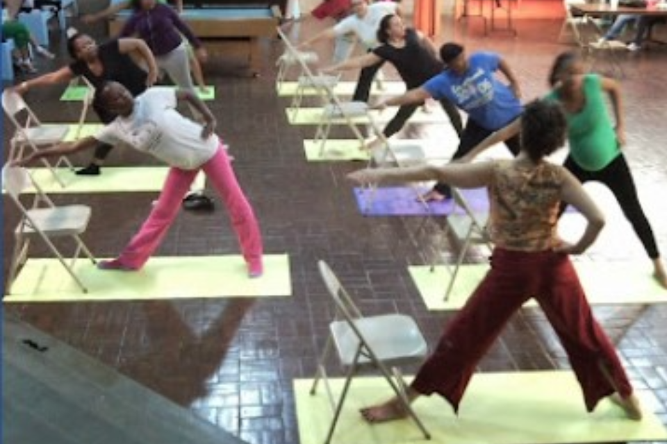 Joni Wellness teaching beginning Iyengar Yoga utthita trikonasana, triangle pose, with a chair, pre-natal.