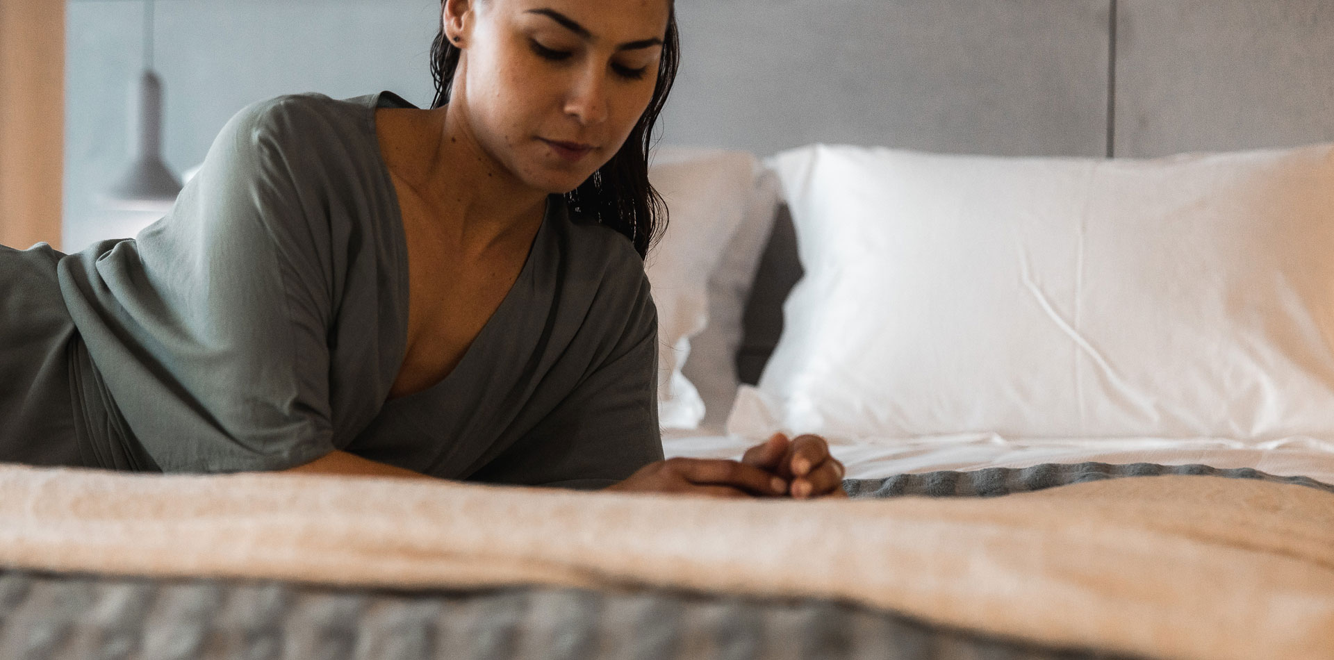 Girl laying in bed in Ogarden Suites