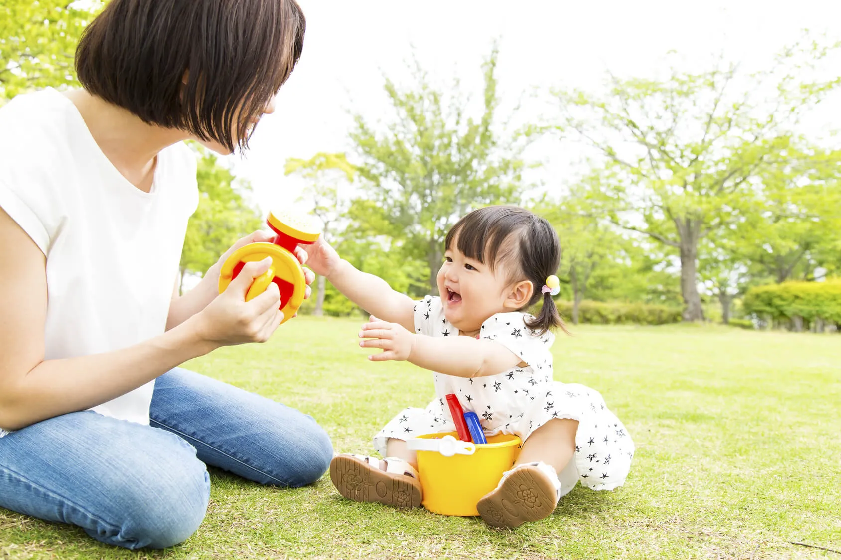 公園で赤ちゃんと遊ぶ親子