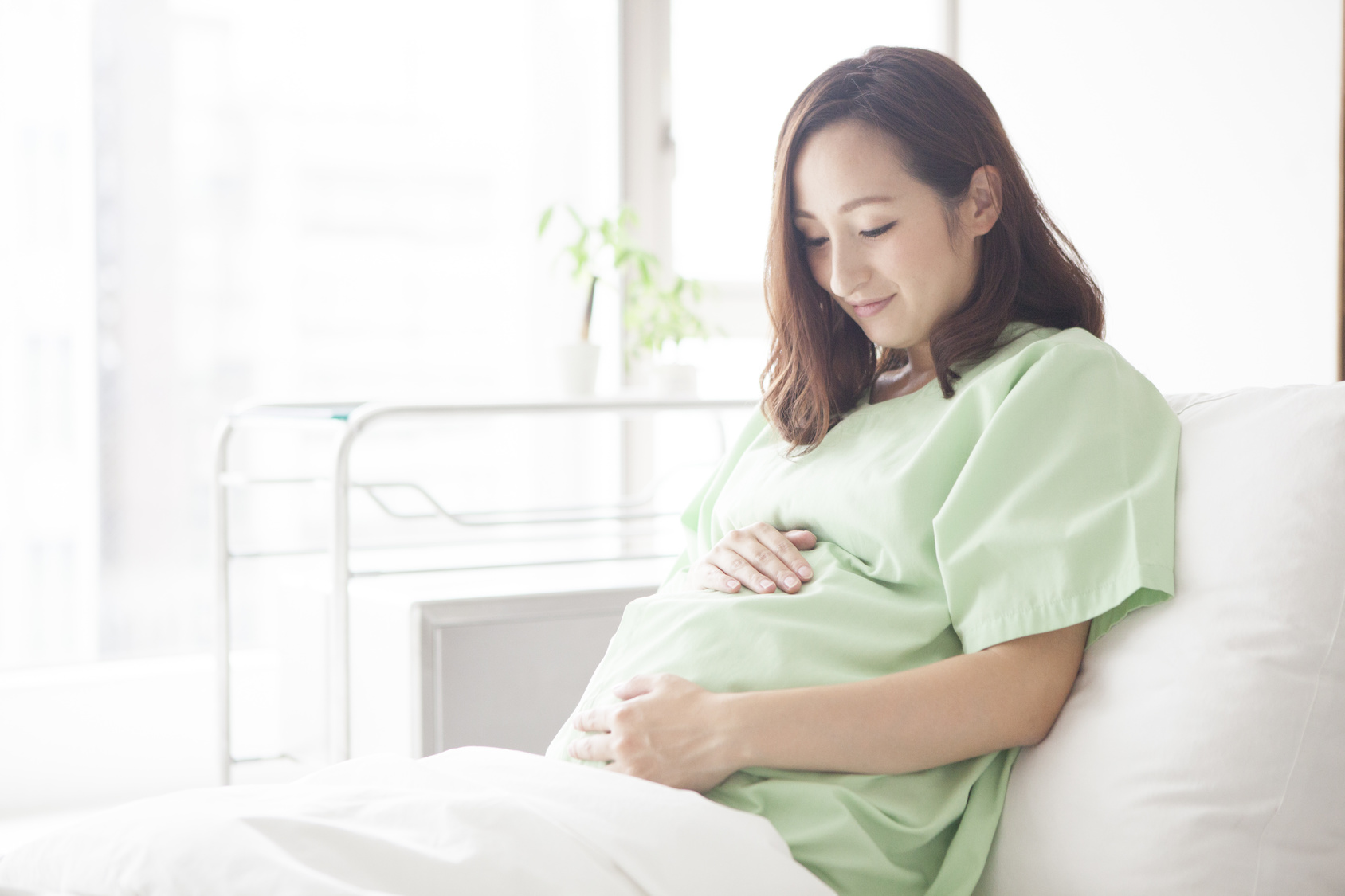 病院のベットの上にいる妊婦