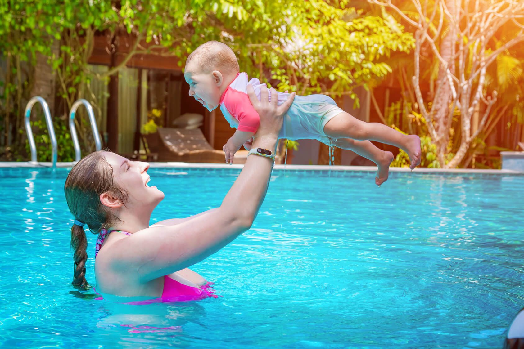 プールで赤ちゃんと遊ぶ母親