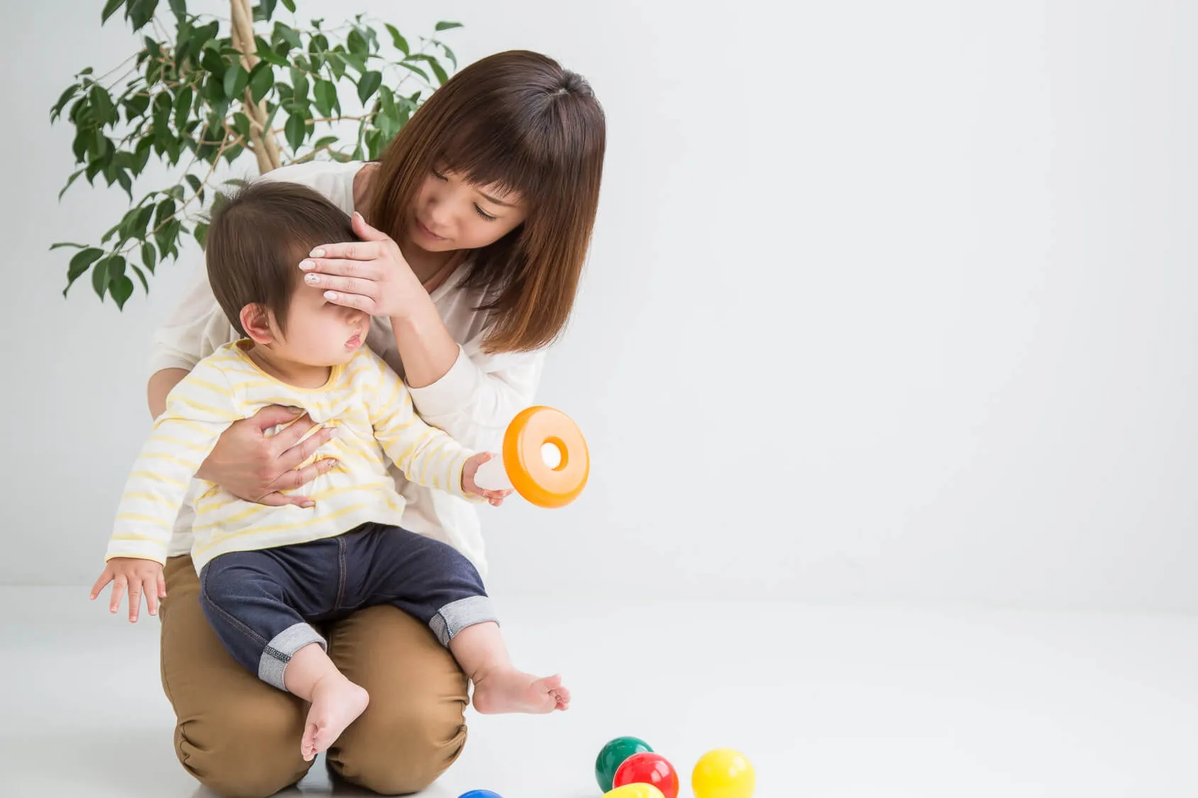 熱が出てる子供を看病する女性