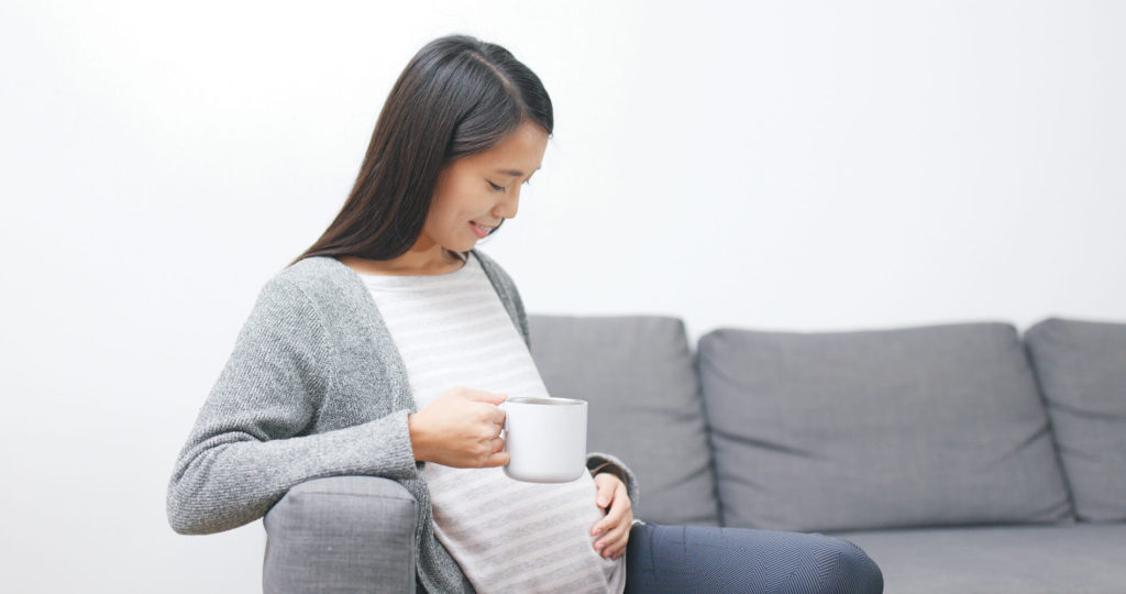 飲み物を飲む妊婦