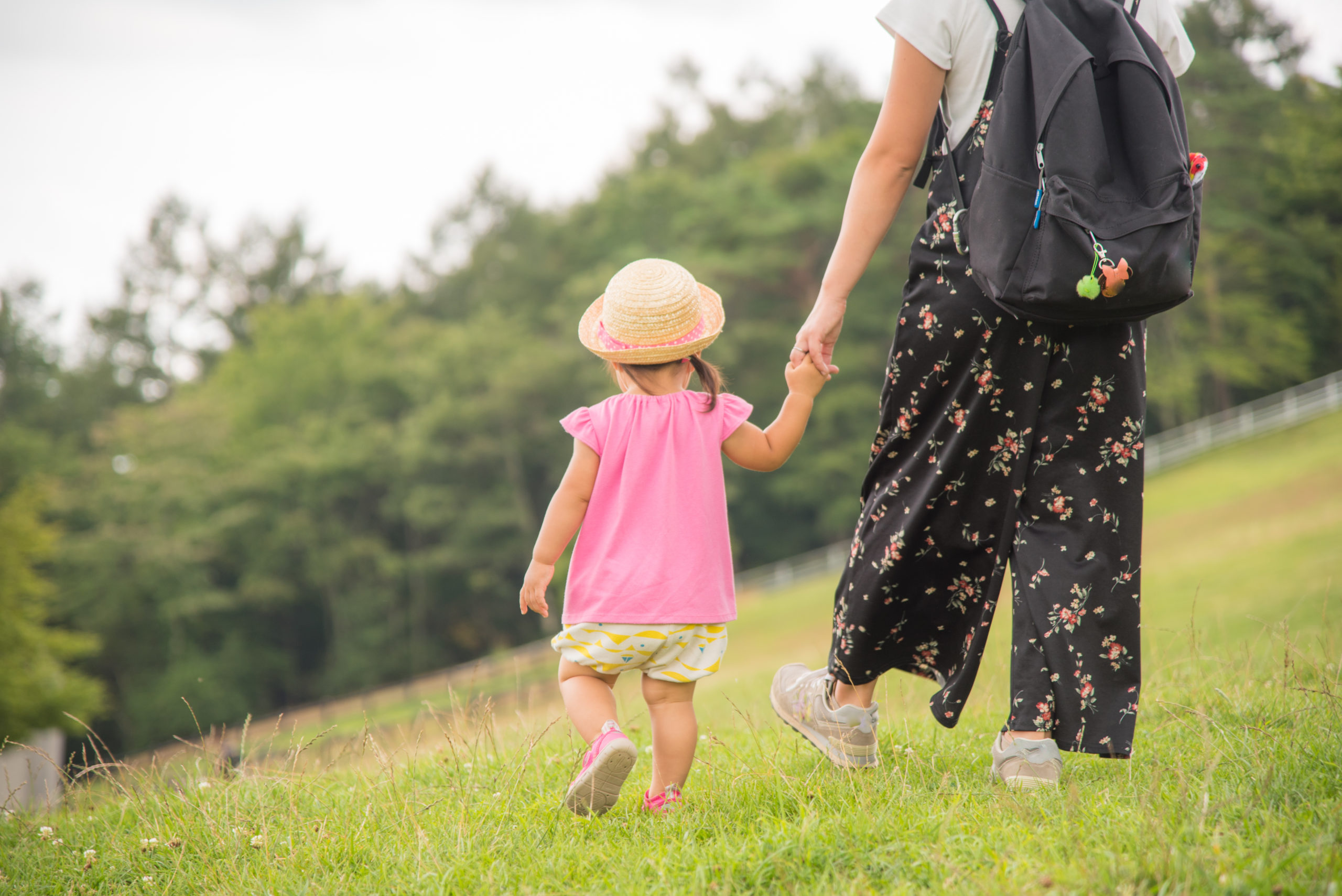 芝生の上を散歩する母親と子供