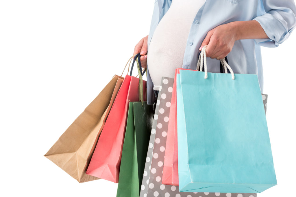 cropped view of pregnant woman with shopping bags isolated on white