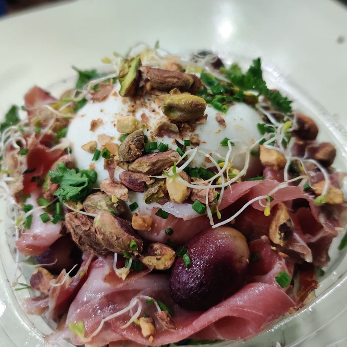 Burrata salad with candied grapes, arugula, Iberian ham shavings, and pistachio vinaigrette