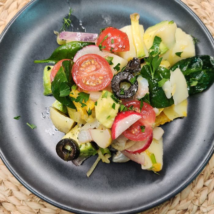 Potato salad with orange, tomato, onion, cod, and avocado