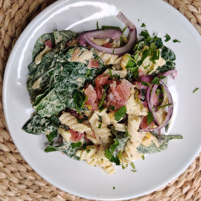AManida de pasta amb salsa tartara, ceba, espinacs, cogombre, blat de moro i pernil