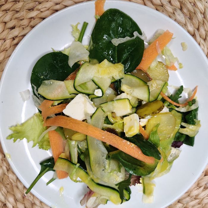 Amanida de verds amb tires de carbassó i pastanaga, cogombret, vinagreta de mostassa i formatge feta