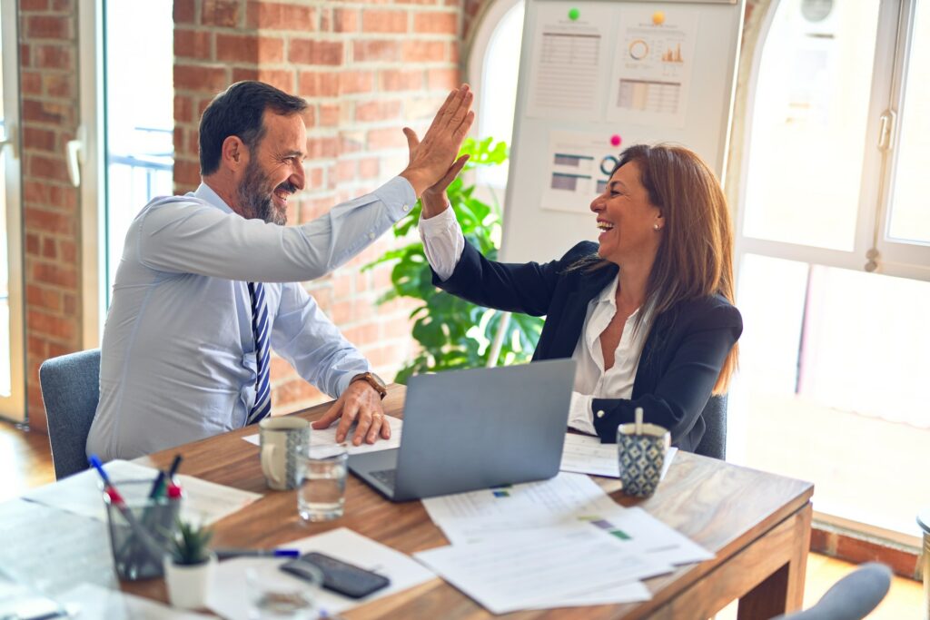 duas pessoas comemorando o sucesso das ações implementadas para gestão de pessoas