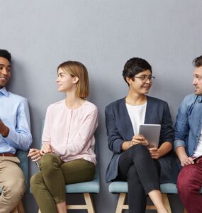 4 pessoas conversando sentadas uma ao lado da outra.