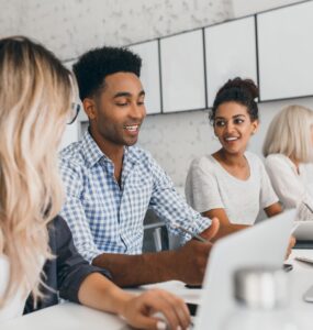 3 colegas de trabalho conversando enquanto um deles aponta para a tela de um tablet