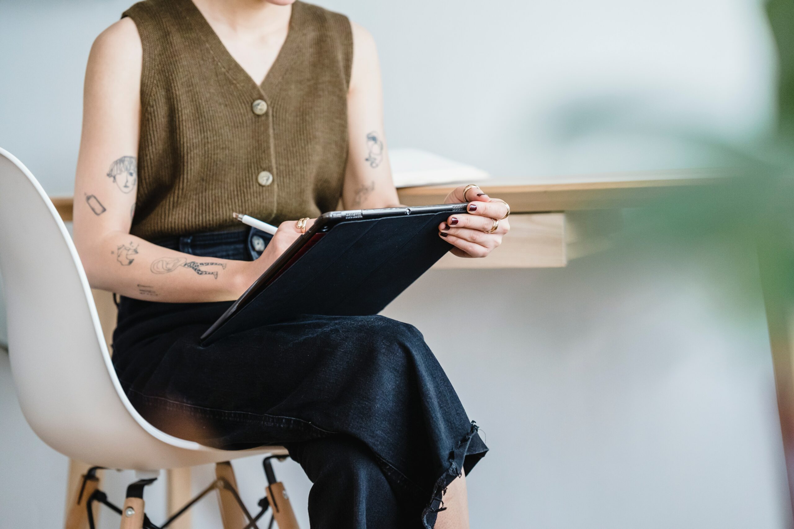 mulher sentadas com uma caneta anotando em tablet