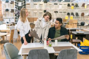 equipe em reuniçao, duas mulheres e um homem conversam sobre projetos colocados a mesa