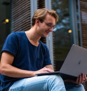 homem com notebook no colo