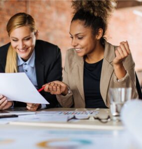 Duas mulheres sentadas à mesa decidindo uma nova estratégia de alocação de recursos