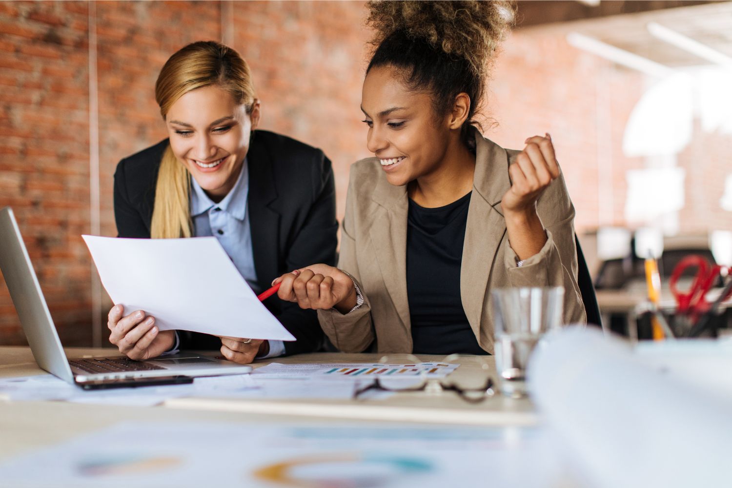 Duas mulheres sentadas à mesa decidindo uma nova estratégia de alocação de recursos