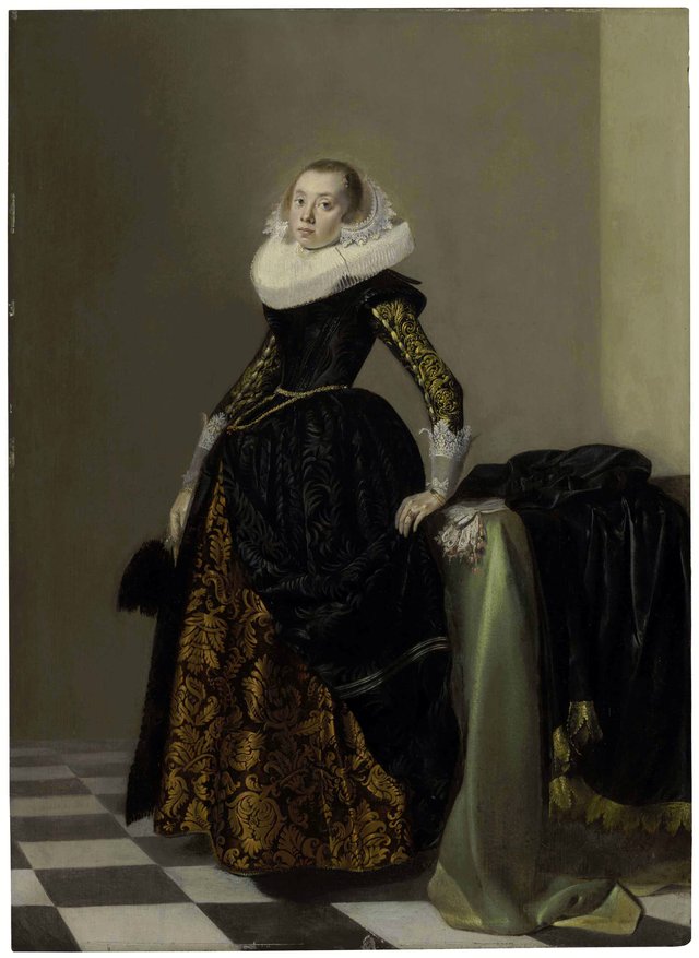 Portrait of a richly dressed young lady, full-length, before a draped table by Pieter Codde