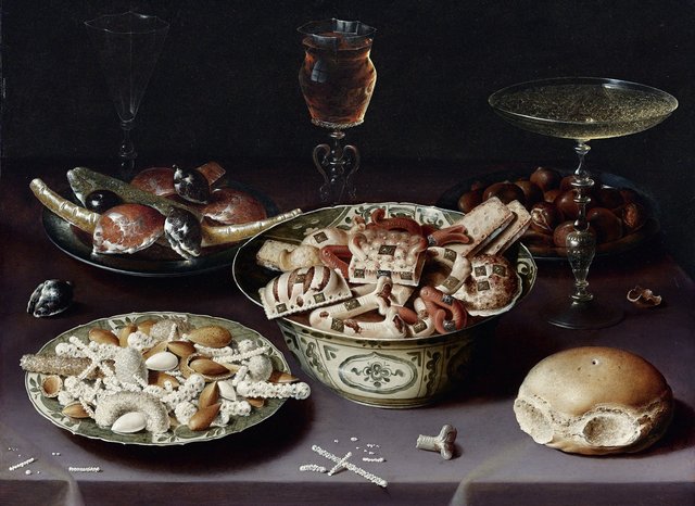Still life of porcelain vessels containing sweets, pewter plates bearing sweets and chestnuts, three pieces of glassware and a bread roll on a table draped with a mauve cloth by Osias Beert