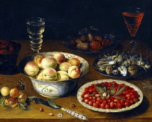 Fruit still life with two wine glasses on a wooden table by Osias Beert