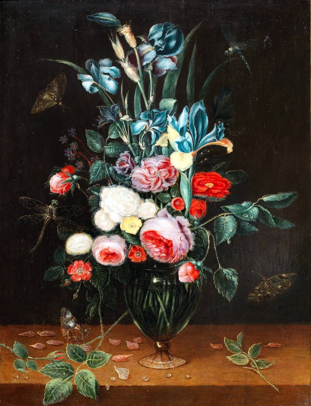 Irises, roses and other flowers in a glass vase on a wooden table with butterflies and dragonflies by Alexander Adriaenssen