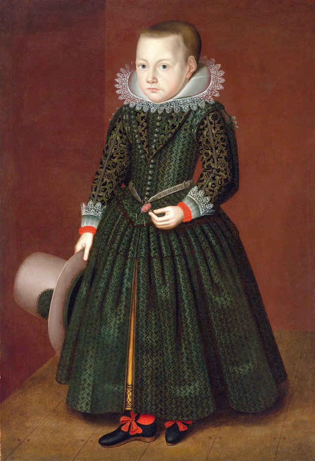 Portrait of a young boy, standing, in skirts, holding a plumed hat. by Wybrand de Geest