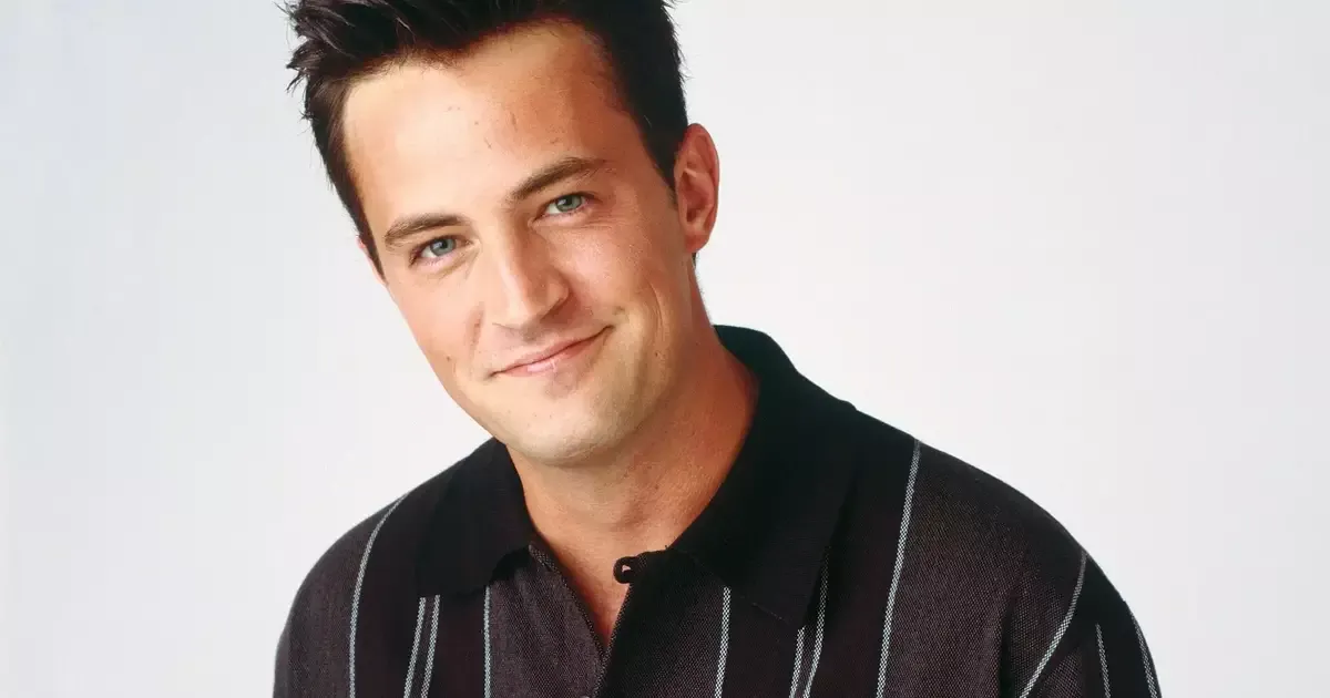 Matthew Perry sorrindo em retrato de divulgação com camisa listrada e fundo claro, ligado à série documental da Netflix