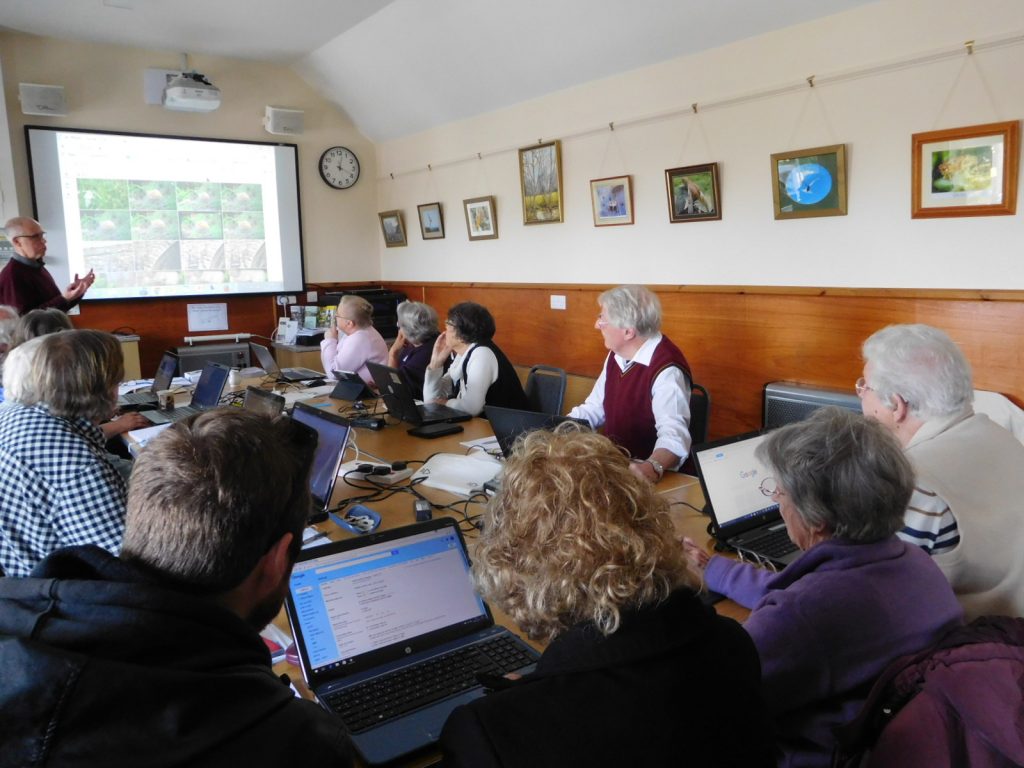 Jeff at large screen at front of group of people with laptops.