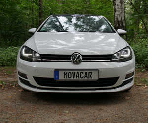 Movacar Fahrzeug Weißer VW Golf im Wald mit einem Movacar-Kennzeichen