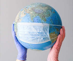 Corona-Pandemie eine Person, die einen Globus mit Handschuhen hält und der Globus hat eine Maske
