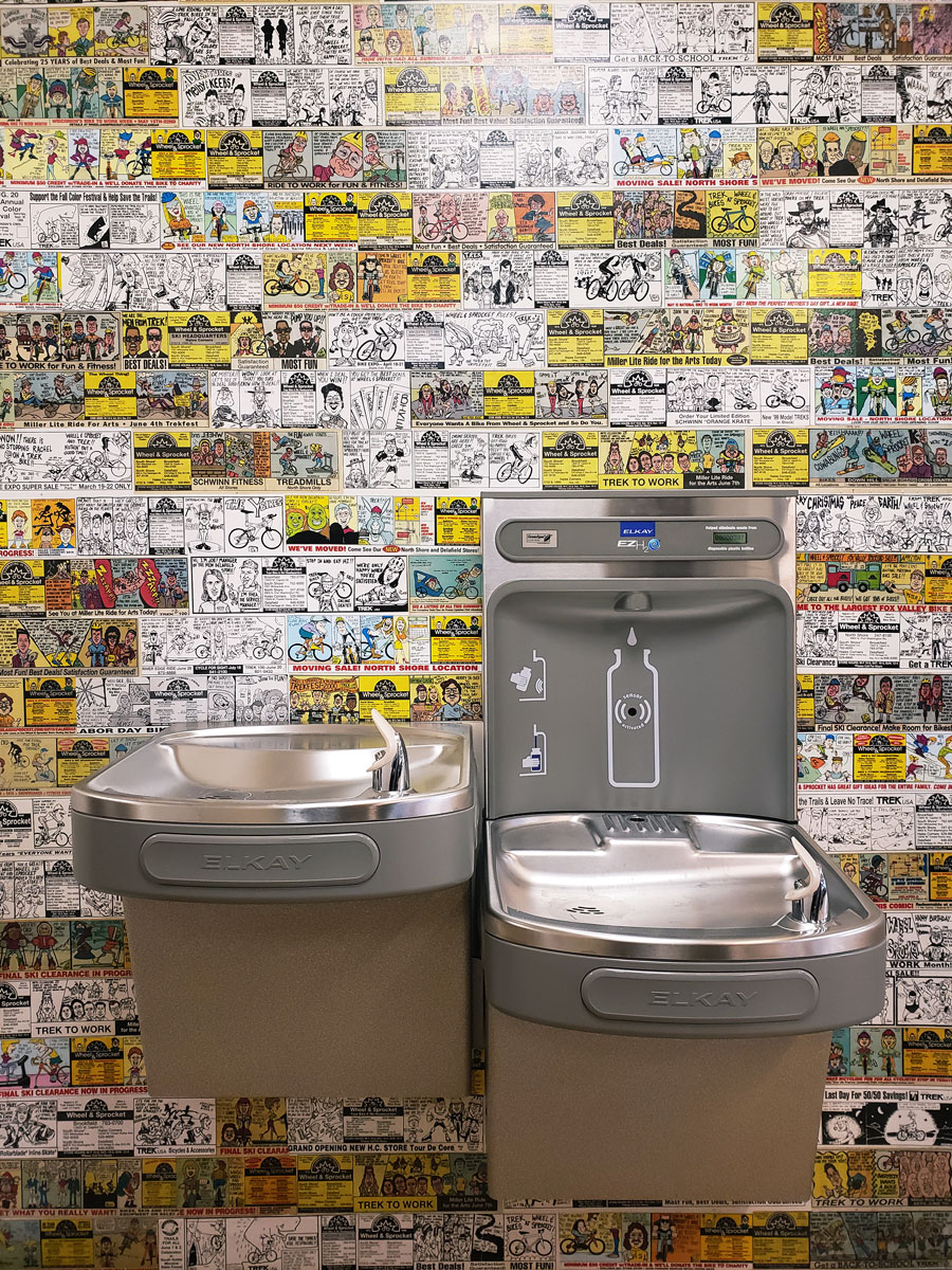 Drinking fountains installed against vintage Wheel & Sprocket newspaper comics.