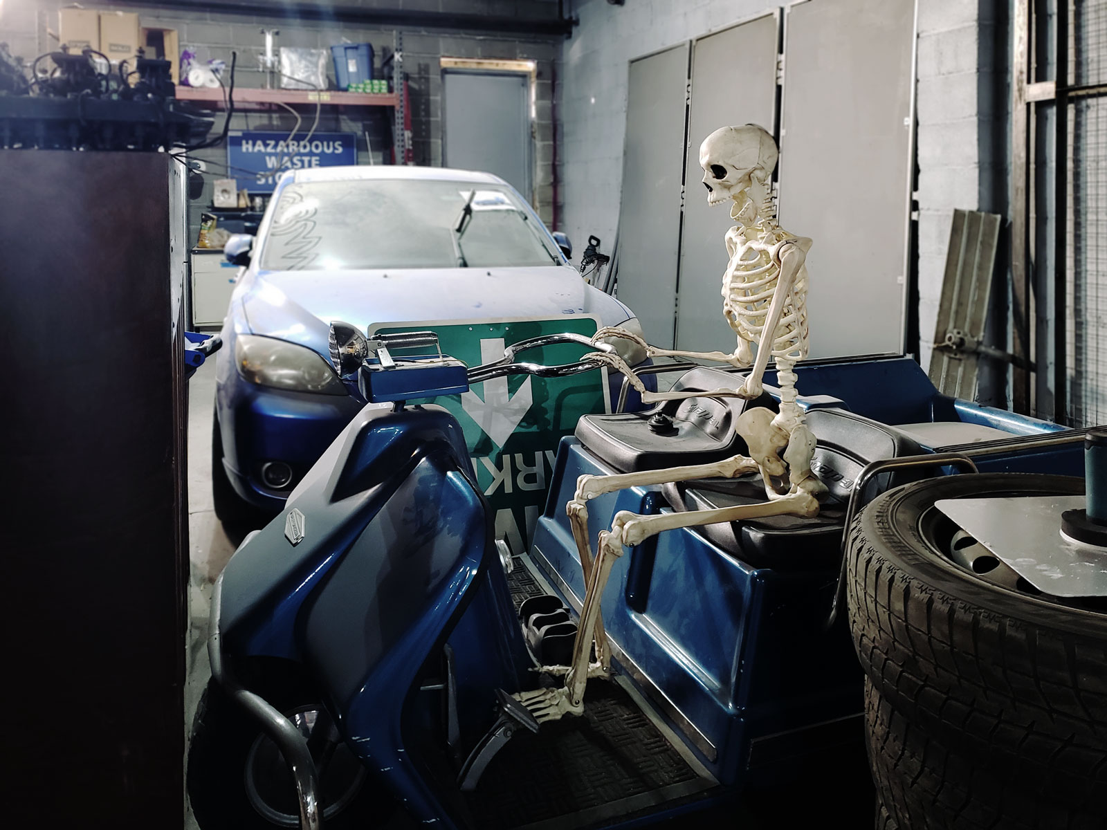 A skeleton riding a scooter.