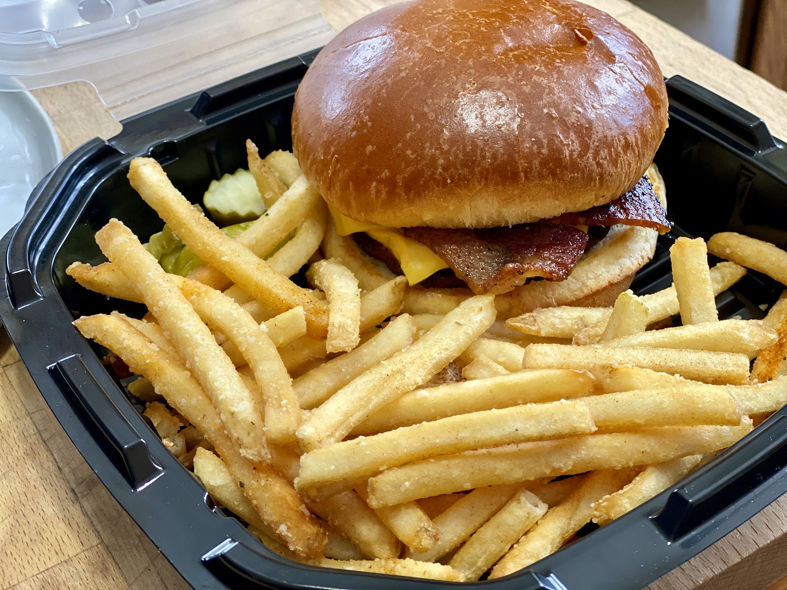 Milwaukee Brat House bacon cheeseburger in a carry-out container