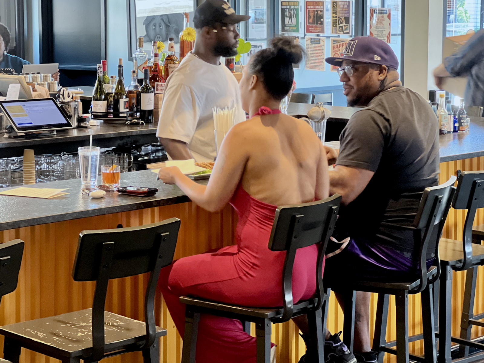 Guests order food at the bar during happy hour.